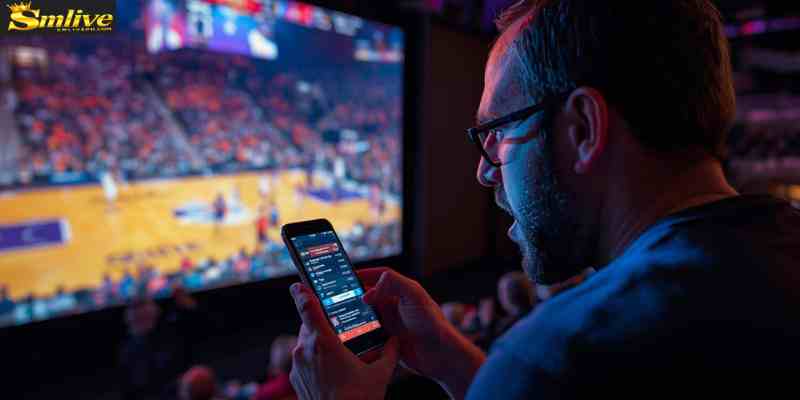 Basketball fan watching a game while using a sports betting app
